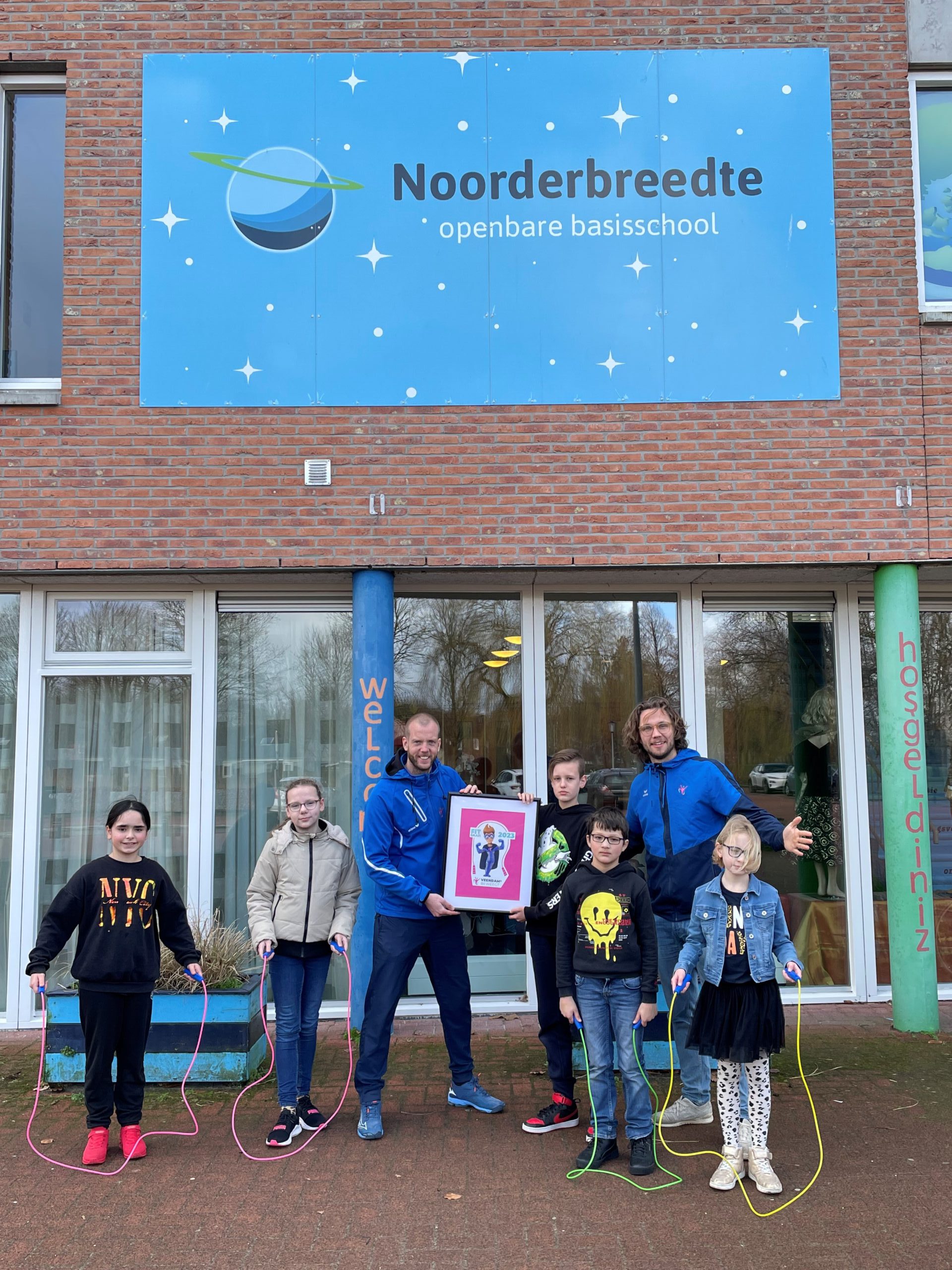 De sportconsulenten van Veendam Beweegt met leerlingen van obs de Noorderbreedte tonen de FitGaaf!sticker