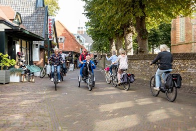 Oudere op een driewielfiets